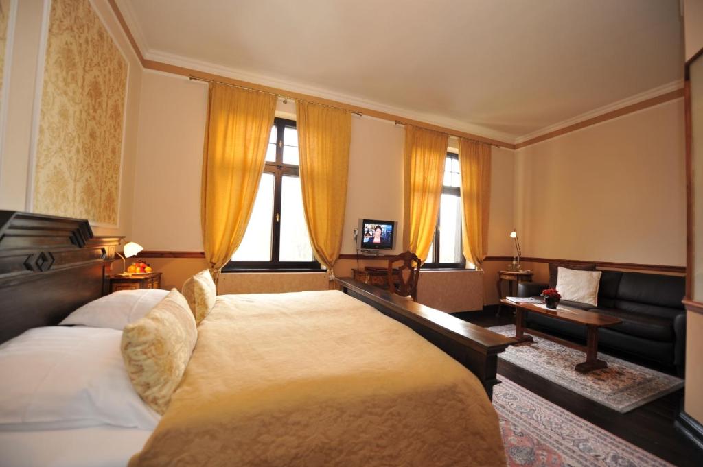 ein Hotelzimmer mit einem Bett und einem Sofa in der Unterkunft Gutshaus Kubbelkow in Bergen auf Rügen