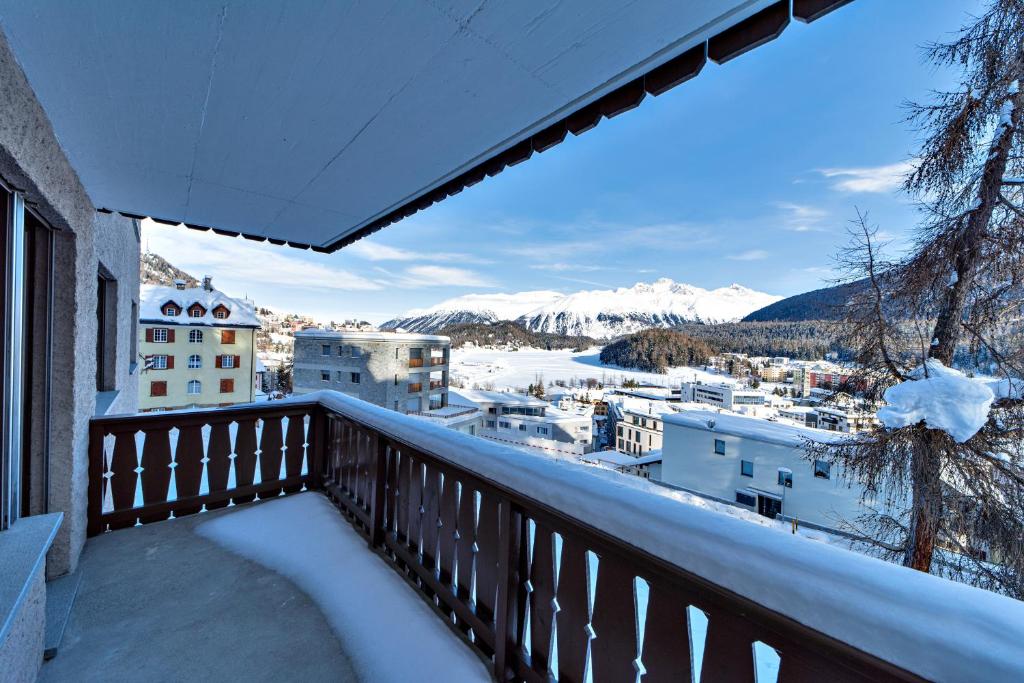uma varanda com vista para as montanhas cobertas de neve em Chesa Aruons 21 - St. Moritz em St. Moritz