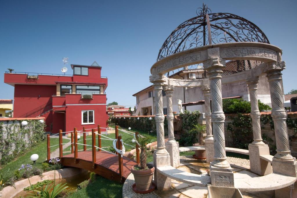 a gazebo with a bridge and a building at Il Mondo B&B in Fiumicino