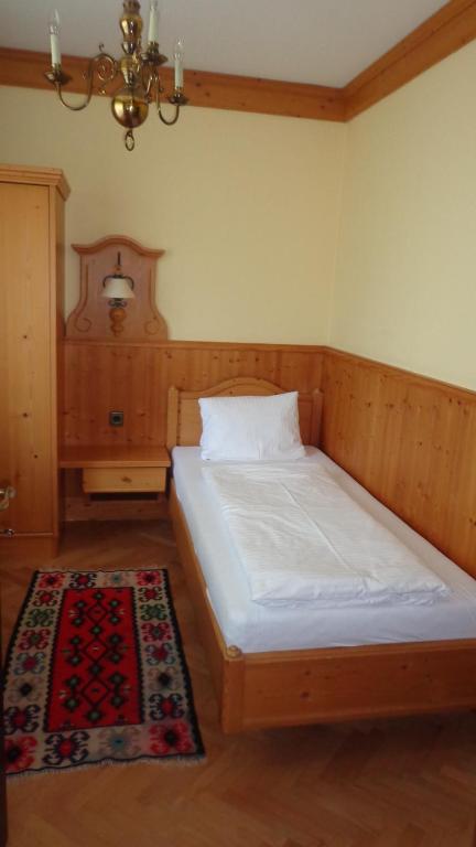 a bedroom with a bed and a rug at Hotel Restaurant - Häuserl im Wald Graz in Graz