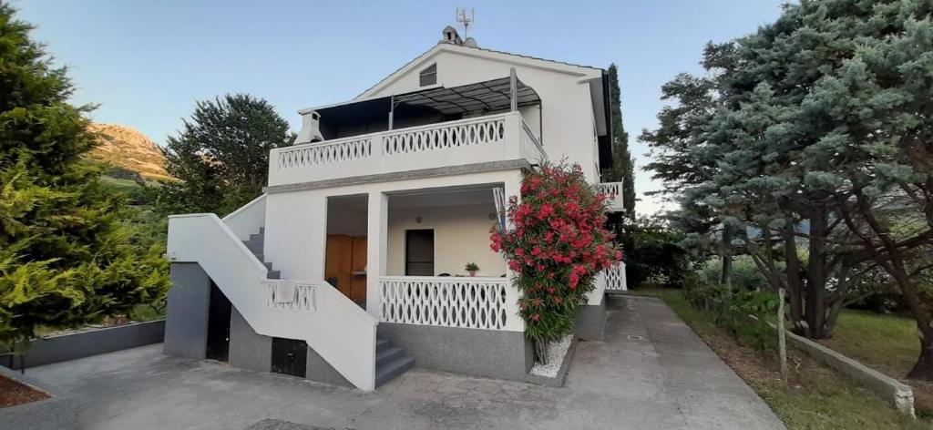 a white house with a staircase in front of it at Apartman Ana in Draga Bašćanska