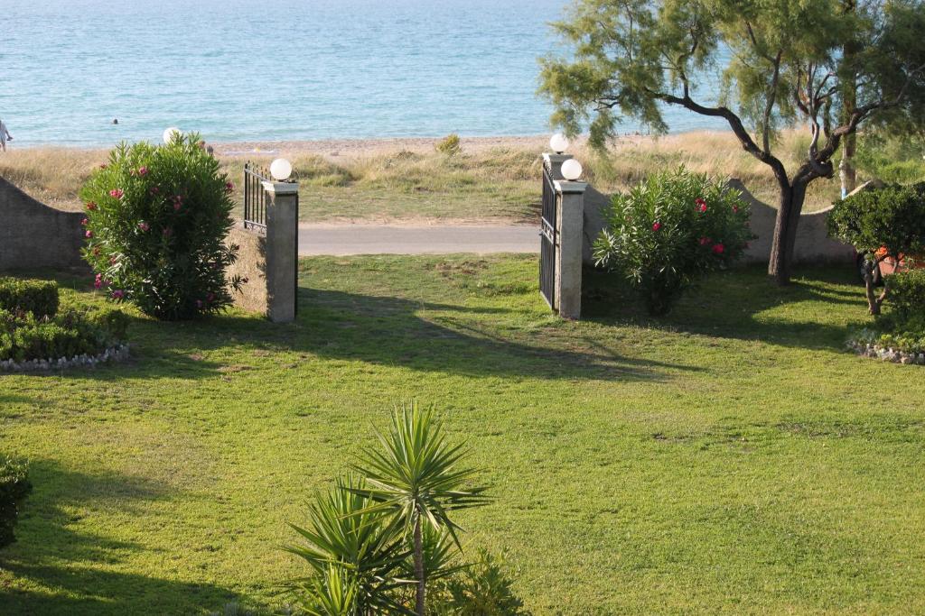 a gate in a field with the ocean in the background at Villa Angela, seafront apartments, Almiros beach in Almiros Beach