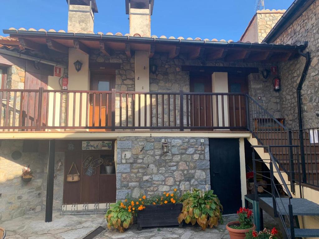 a house with a balcony and flowers in front of it at Ca L'Isidret in Lles