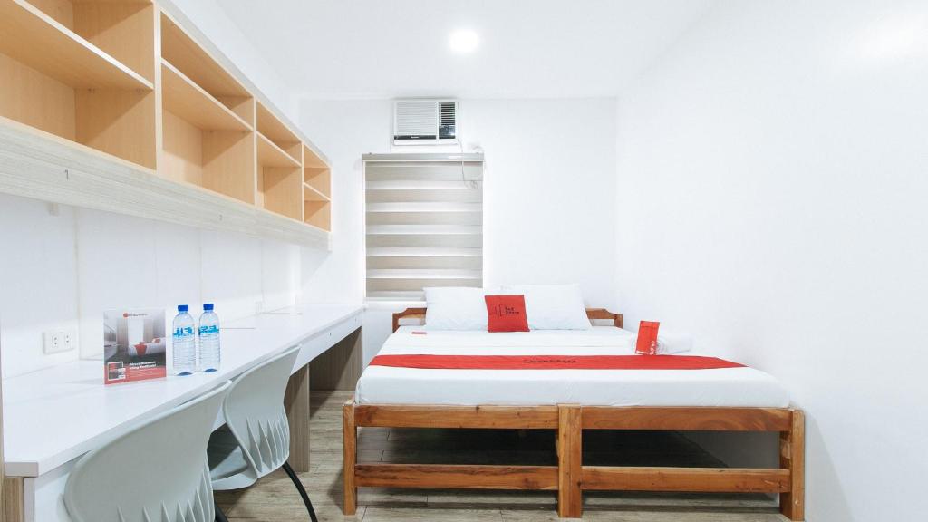 a small room with a bed and shelves at RedDoorz Plus @ 1318 Residences in Manila