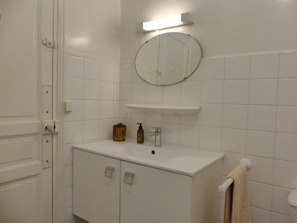 a white bathroom with a sink and a mirror at Appartement Pour 4 Personnes Avec Vue Sur Le Canal Du Lac Marin- Residence Du Lac in Hossegor