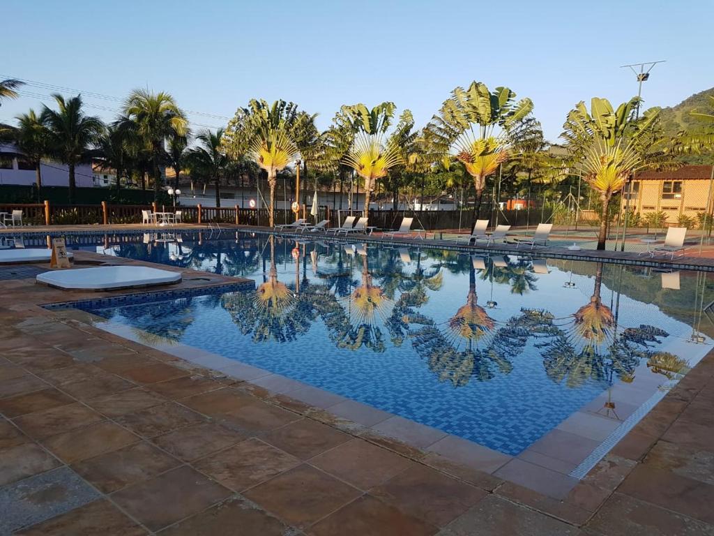 una piscina con palmeras y agua azul en Maresias Beach Home - Mata Azul en Maresias