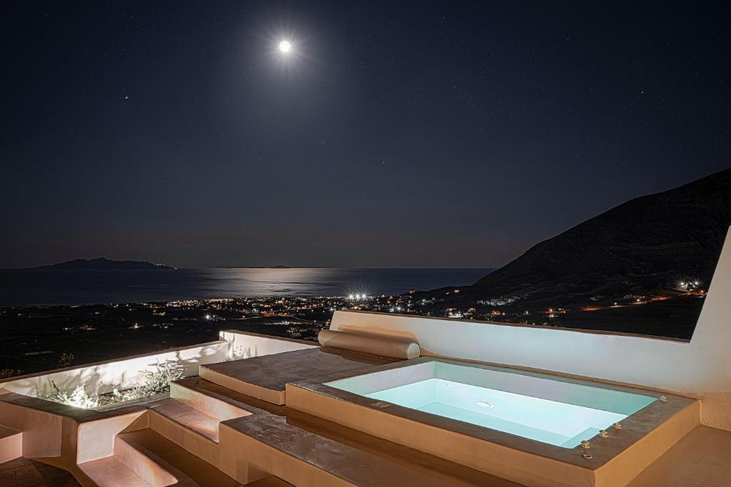 a bath tub on a balcony at night with the moon at Terra e Lavoro Luxury Suite in Éxo Goniá