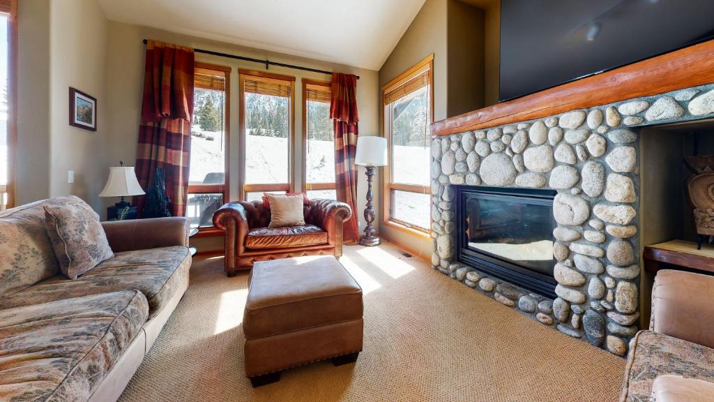 a living room with a large stone fireplace at Snowcreek V #774 condo in Mammoth Lakes