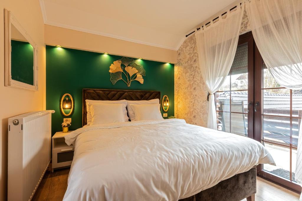 ラコヴィツァにあるVilla Park Plitviceの緑の壁のベッドルーム1室(大型ベッド1台付)