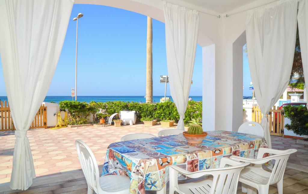 una mesa y sillas en un patio con vistas al océano en Villetta Maredorat Vista Mare by HDSalento, en Torre Vado