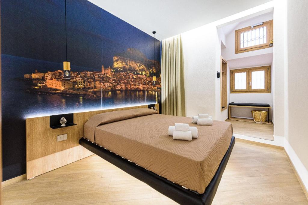 um quarto com uma cama com um quadro na parede em Incao Holiday Il Moro House em Cefalù