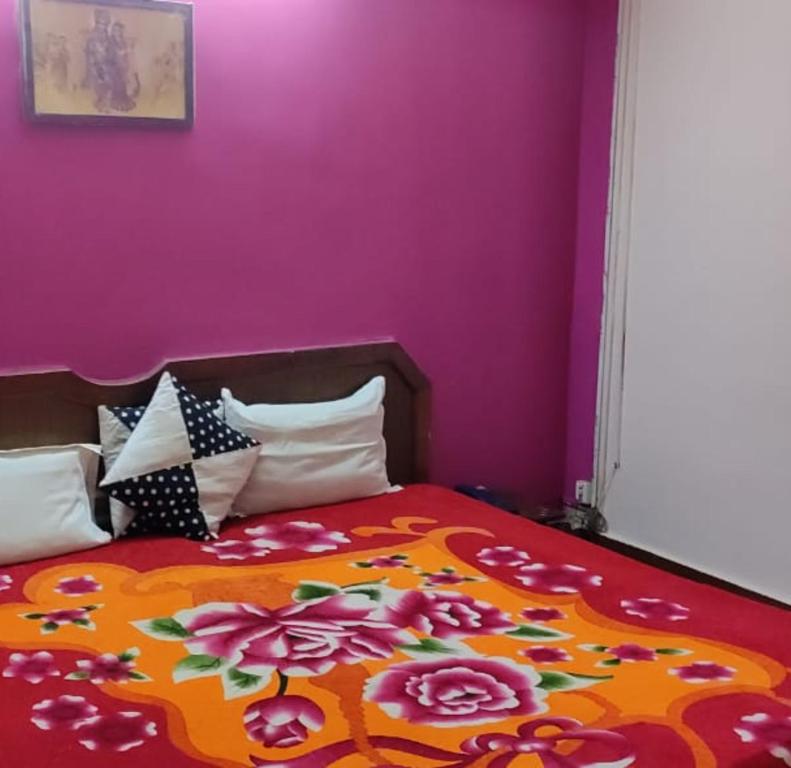 1 dormitorio con 1 cama con pared morada en Narayan Vishal By WB Inn, Patna, en Patna