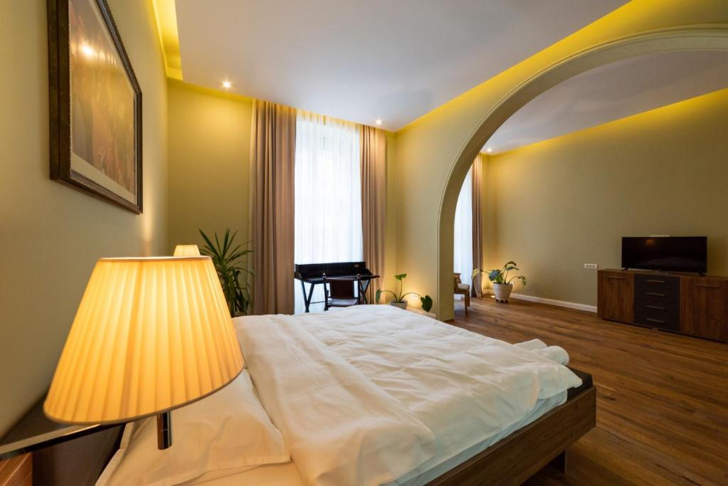 Un dormitorio con una cama con una lámpara y una ventana. en Casa Nym, en Brasov