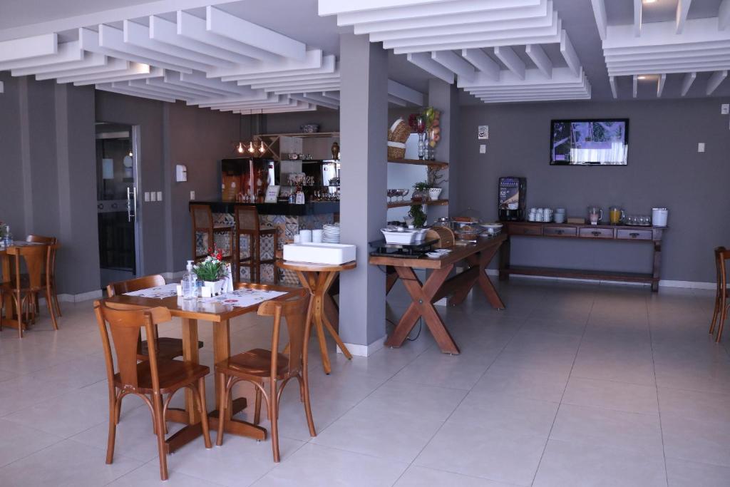 uma sala de jantar com mesas e cadeiras de madeira em Alfa Hotel Teresina em Teresina