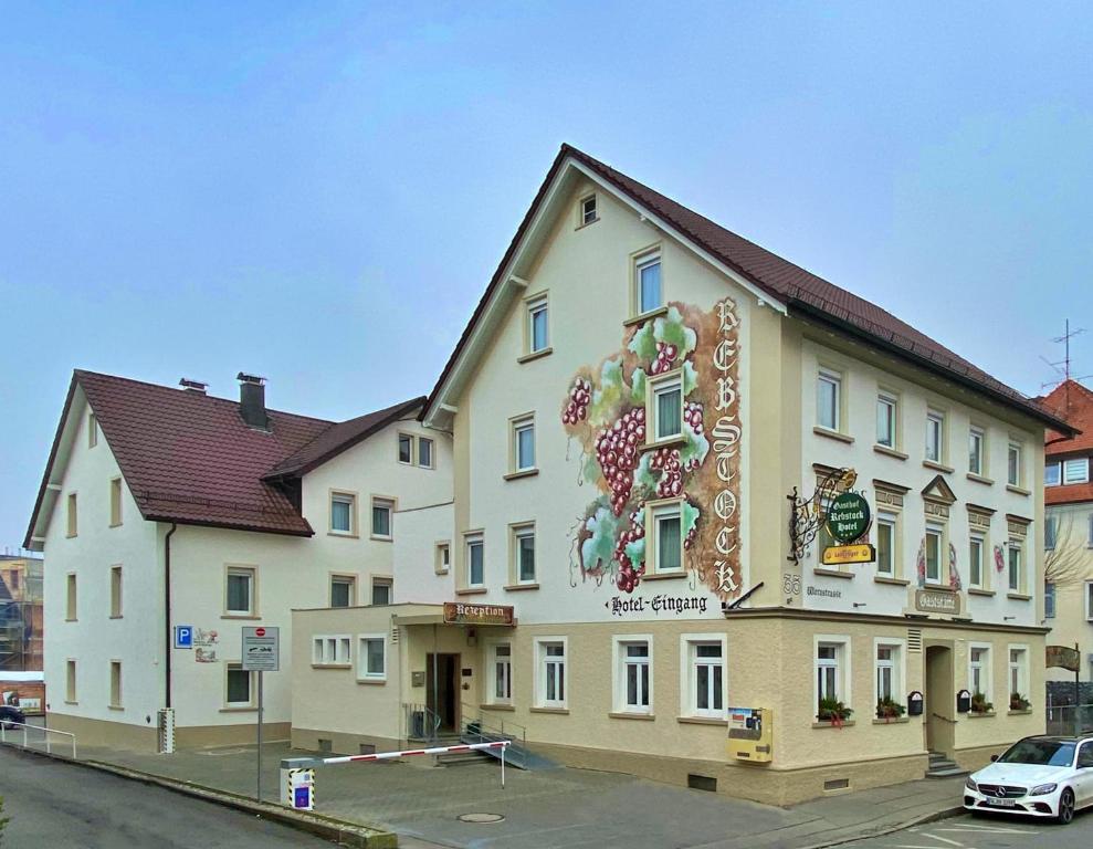 un grand bâtiment avec un panneau sur son côté dans l'établissement Gasthof Rebstock, à Friedrichshafen