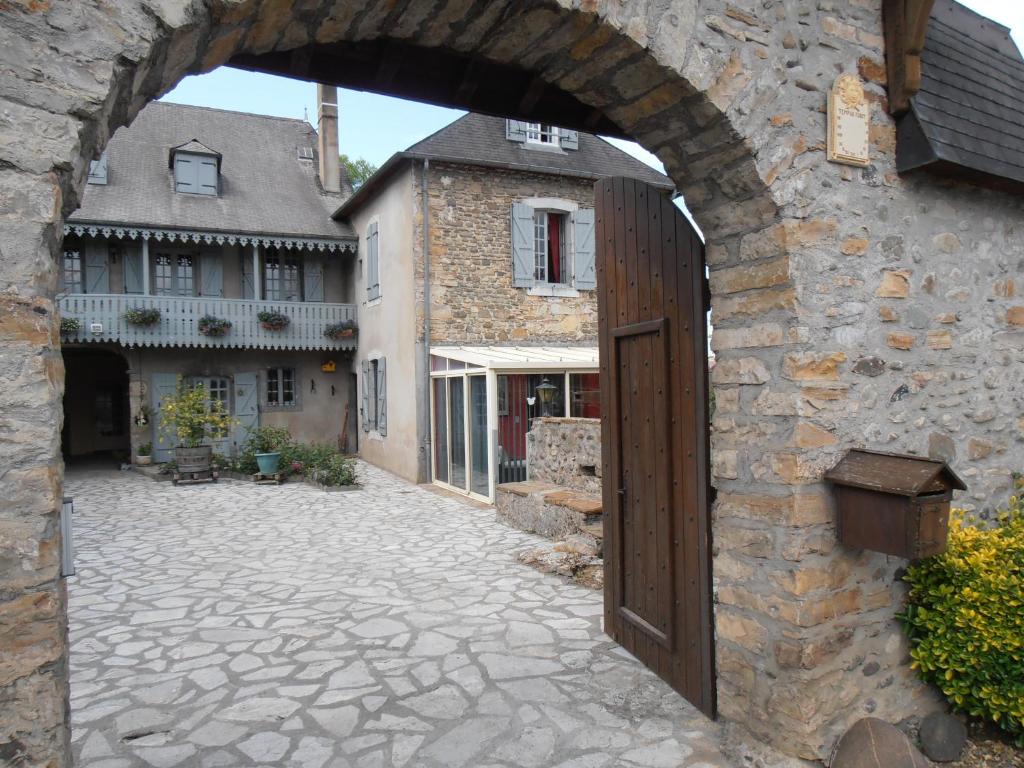 una entrada a un edificio de piedra con puerta de madera en Gîte Tuyaret, en Oloron-Sainte-Marie