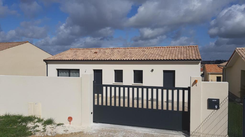 una casa blanca con una puerta negra y una valla en Maison entière moderne tout confort de 92m², en Angulema