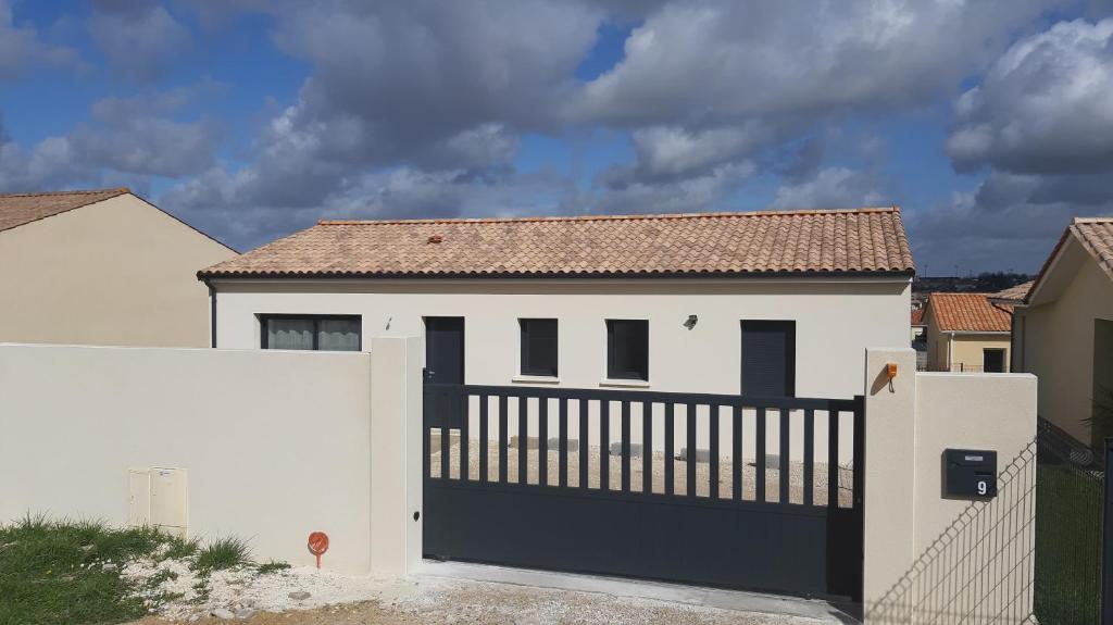 a white house with a black gate and a fence at Maison entière moderne tout confort de 92m² in Angoulême