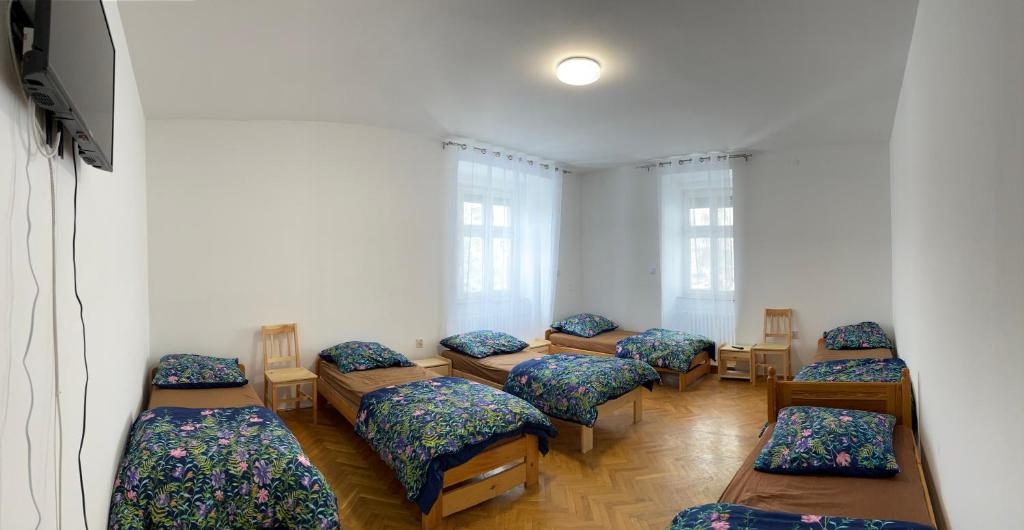 a room with a row of beds with pillows at Apartament 1 dla 6 osób in Bielsko-Biała