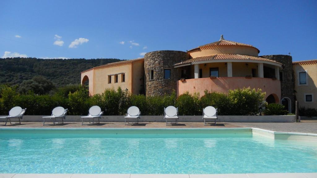 une maison avec une piscine et des chaises en face de celle-ci dans l'établissement Maria Caderina Green Village, à Posada