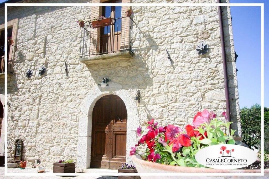 um edifício de pedra com um vaso de flores em frente em Casa Majella di Casale Corneto em Bomba