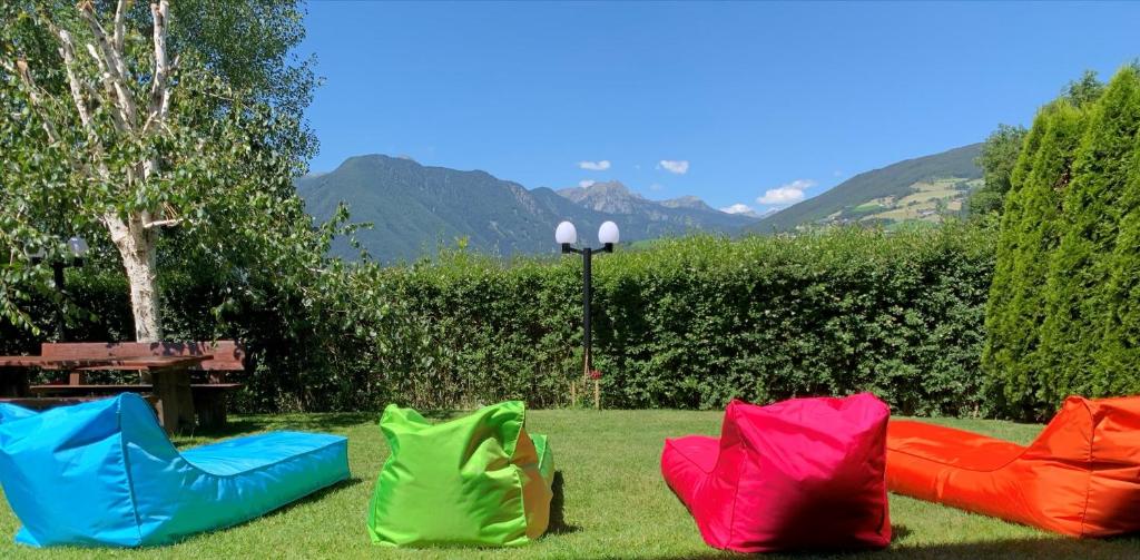 a group of colorful chairs sitting in the grass at Pension Volgger in Rodengo