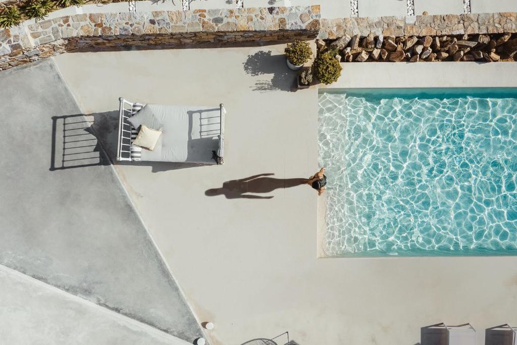 an overhead view of a swimming pool and a person laying on a bed next to at Ayiopetra Exclusive Getaways in Káto Sangríon