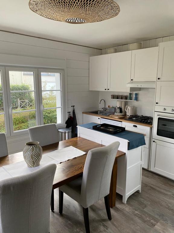 a kitchen with a wooden table and white cabinets at Cottage familial avec jardin - 200m de la plage in Yport