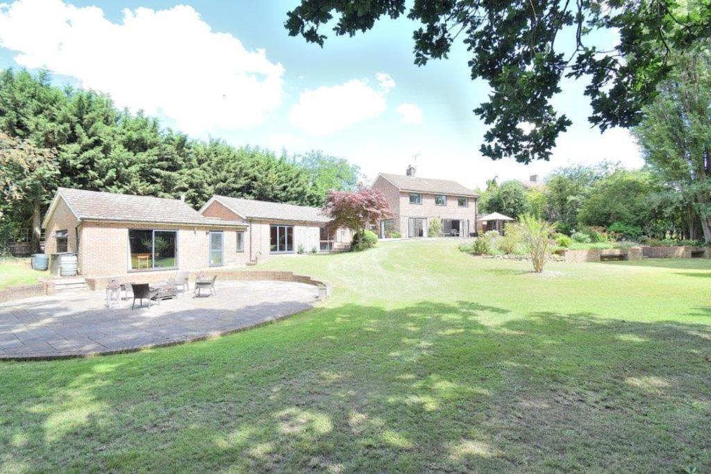 ein Haus mit einem Hof mit einer Terrasse in der Unterkunft Family-Game room-Sleeps 10-Parking-Pets-Bbq in Harlow