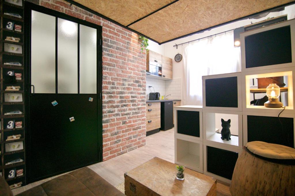 Cette chambre est dotée d'une porte noire et d'un mur en briques. dans l'établissement Studio-résidence front de mer ⎮ parking gratuit, à Bandol