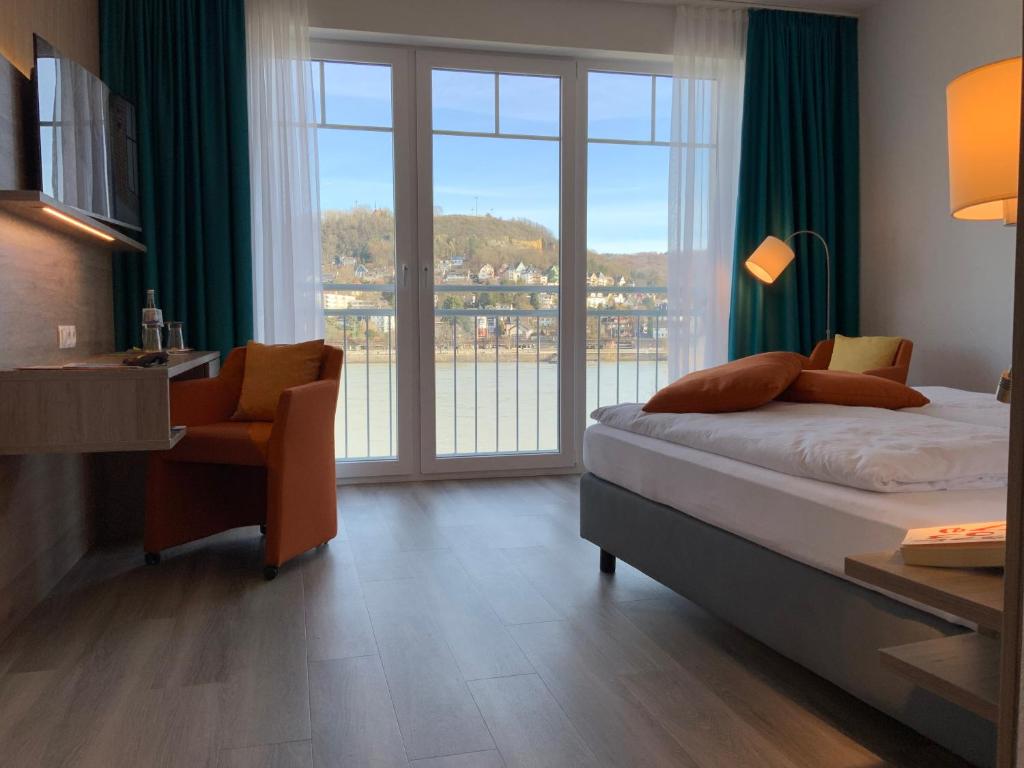 1 dormitorio con cama, escritorio y ventana en RheinVilla ARTE en Remagen