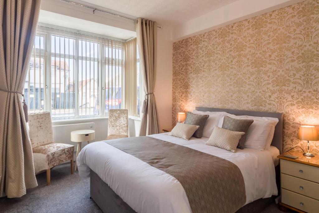 Un dormitorio con una cama grande y una ventana en The Fountaindale Skegness, en Skegness