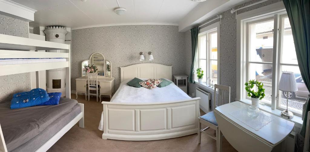 a bedroom with a large white bed and a desk at STF Hostel Mariestad in Mariestad