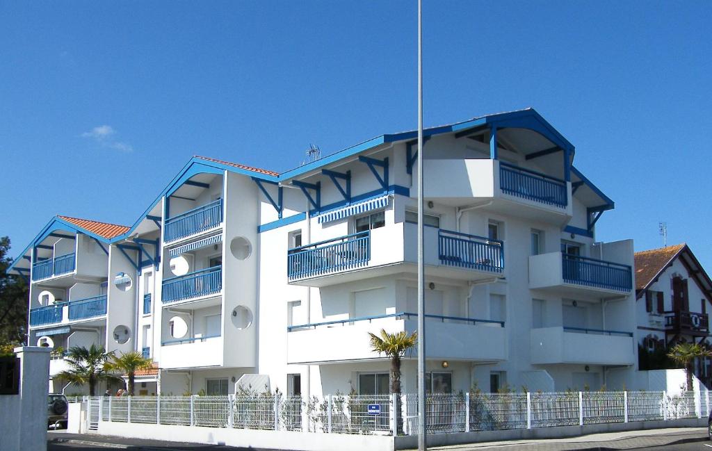 - un immeuble blanc avec balcon bleu dans l'établissement Appartement Rez-De-Chaussee 4 Personnes Face Au Port De Peche- Residence Le Magellan, à Capbreton
