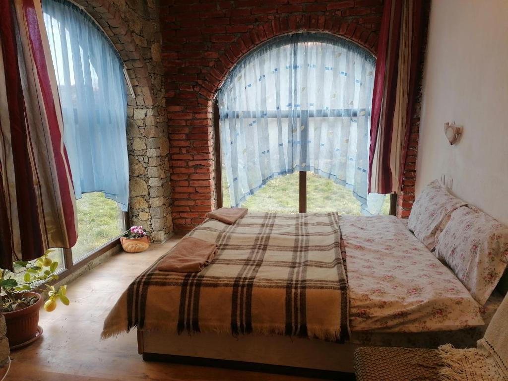 um quarto com uma cama em frente a uma janela em Лилянината къща em Kalofer