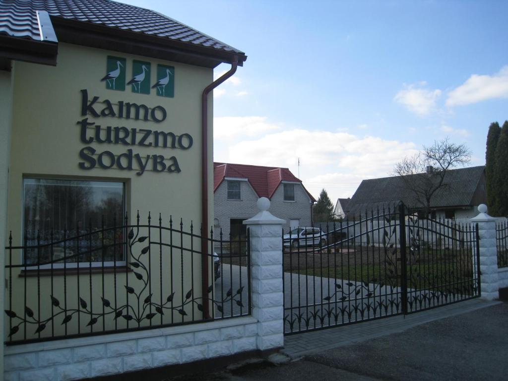 Raudonė的住宿－斯塔西奧波塞威西奧斯後牧斯戴德酒店，房屋前的栅栏上的一个标志