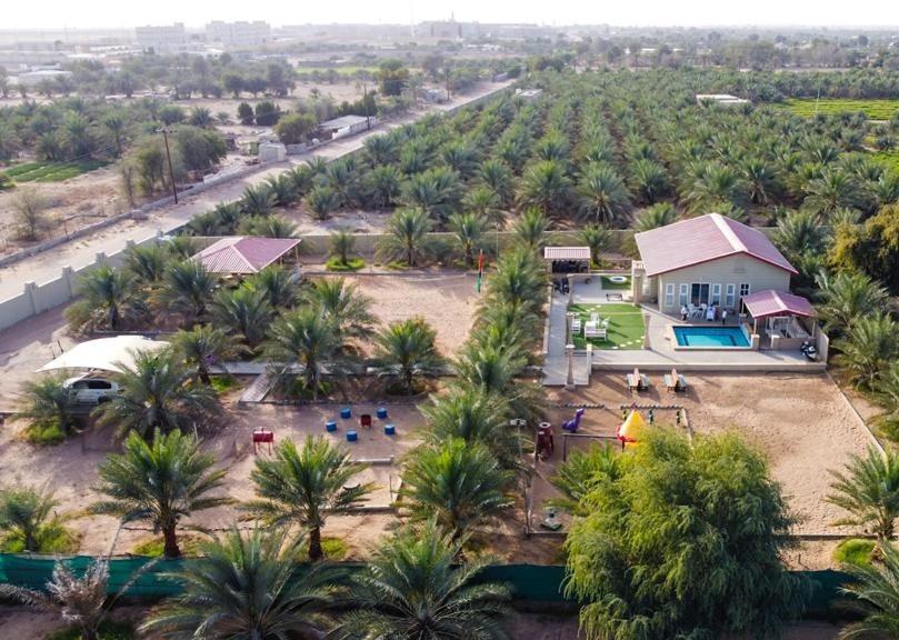 an aerial view of a resort with a lot of palm trees at Al Reef Rest House in Al Khārī