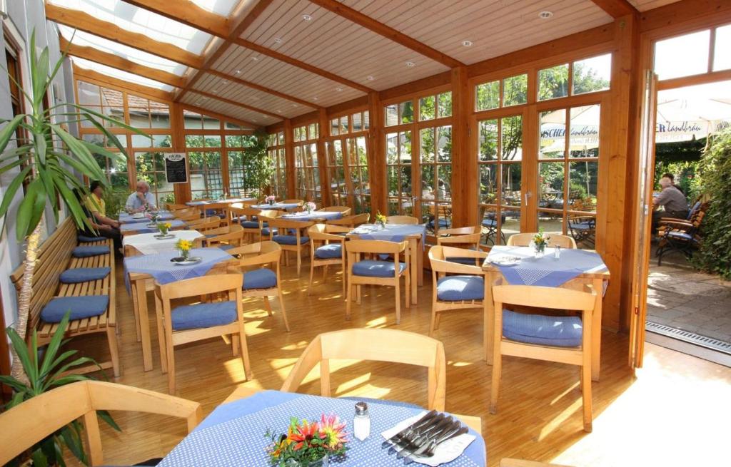 フォイヒトヴァンゲンにあるGasthaus Sindel-Buckelの青いテーブルと椅子、窓のあるレストラン
