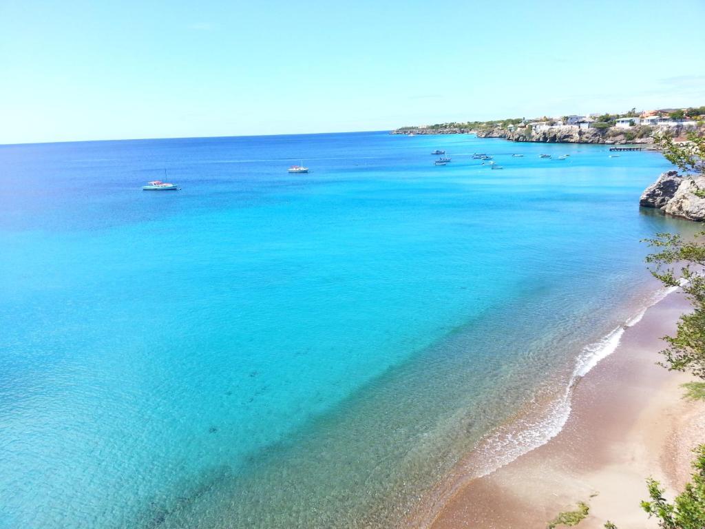 a view of a beach with boats in the water at Blue View Apartments in Sabana Westpunt