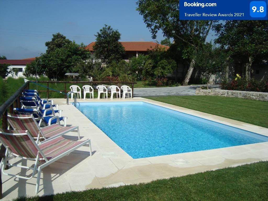 a swimming pool with lounge chairs next to a yard at Quinta do Sobrado in Braga