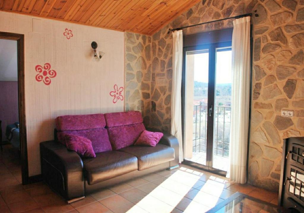 sala de estar con sofá y ventana grande en Serrania - Apartamentos El Cabo en Las Majadas