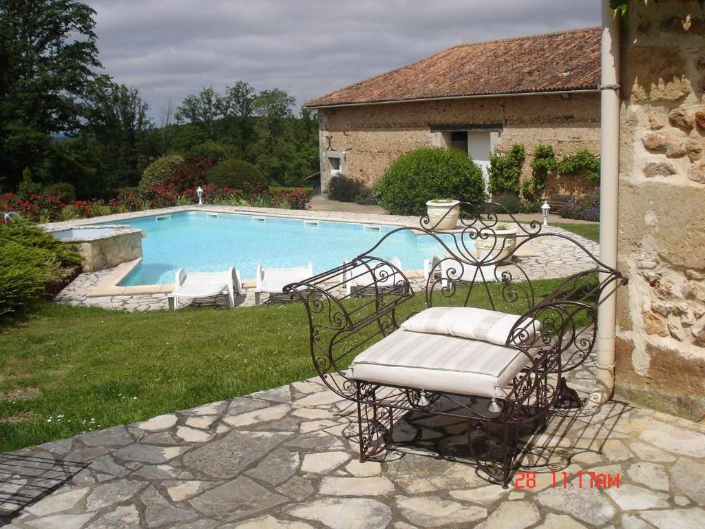 einer Bank vor einem Pool in der Unterkunft Gîte 5/6 personnes aux portes du Périgord in Saint-Adjutory