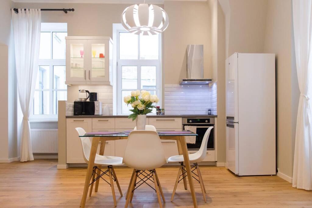 cocina con mesa, sillas y nevera en Modern & Spacious 80m2 Apartment in Riga Old Town, en Riga