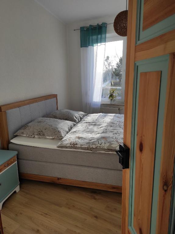Schlafzimmer mit einem Bett und einem Fenster in der Unterkunft Gästehaus Zur Fähre in Coswig