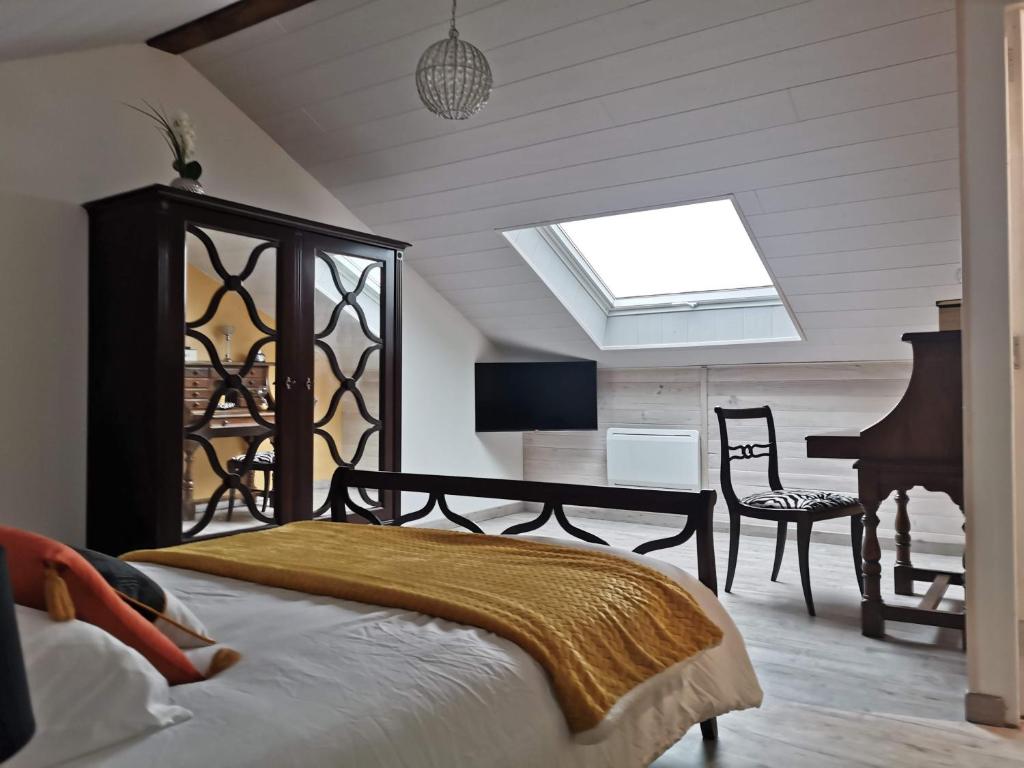 1 dormitorio con cama, escritorio y piano en ETCHE ARGUINIA CHAMBRES HOTES, en Montory