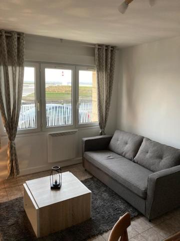 un salon avec un canapé et une table basse dans l'établissement Studio Quai Blavet, à Saint-Valery-sur-Somme