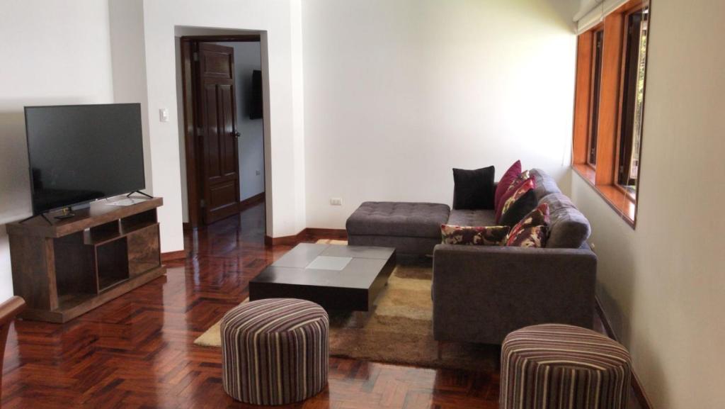a living room with a couch and a tv at Brand New Apartment in Barranco in Lima
