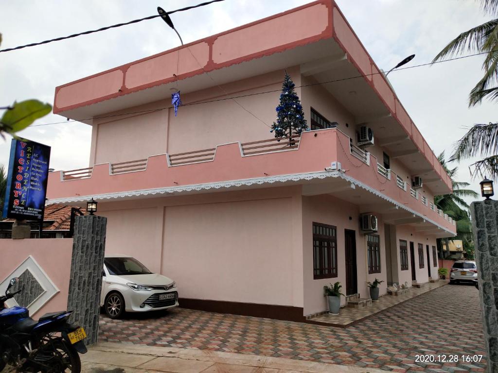 un bâtiment rose avec un arbre de Noël sur lui dans l'établissement Victory's Residence, Mannar, à Mannar