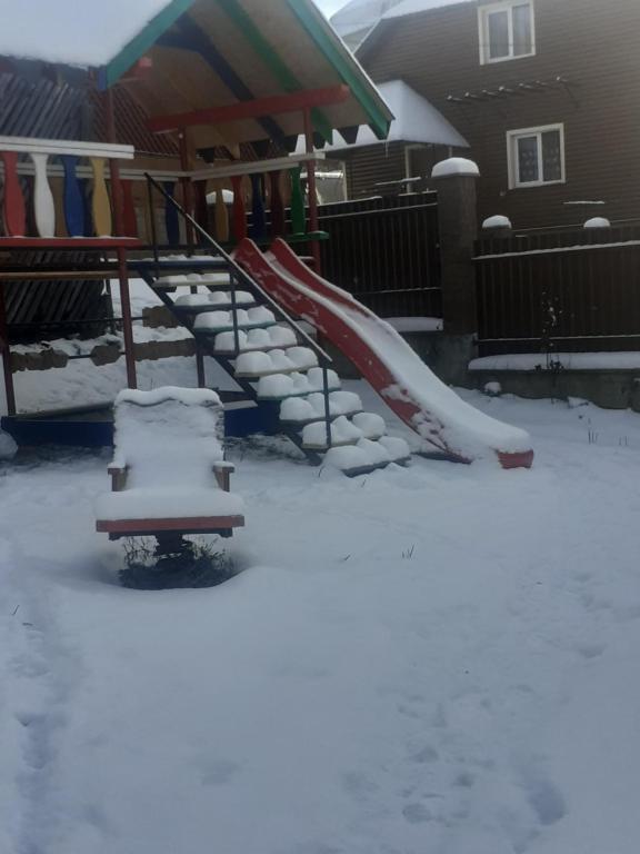 plac zabaw pokryty śniegiem ze zjeżdżalnią w obiekcie Ехо Тростяну w Sławsku