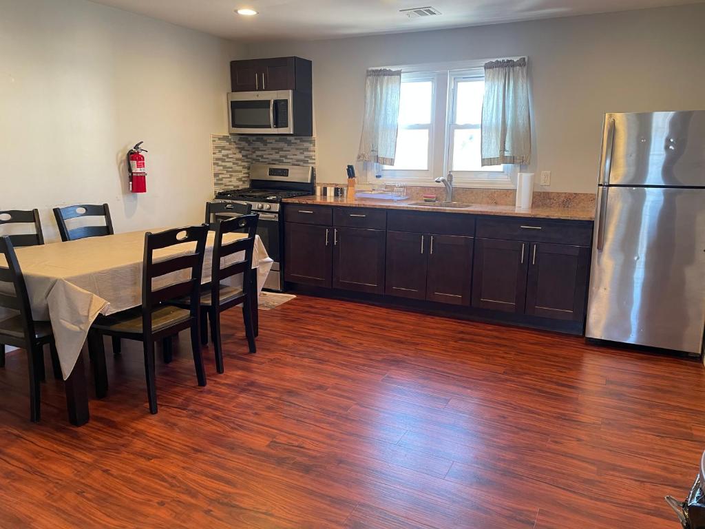 a kitchen with a table and a stainless steel refrigerator at JD Apartment and House in Seaside Heights